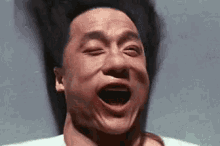 a man is making a funny face with his mouth open and his eyes closed .