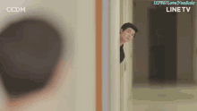 a man peeking out from behind a wall with ccdm on the bottom