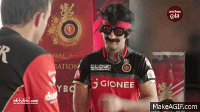 a man wearing a gionee shirt is talking to another man