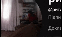 a blurred image of a person sitting in front of a computer with foreign writing