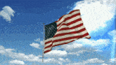 an american flag waving in the wind against a cloudy blue sky