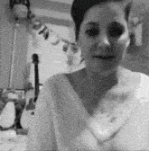 a black and white photo of a woman standing in front of a banner that says happy