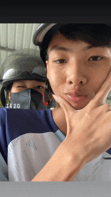 a man wearing a helmet and a mask has the number 1420 written on his shirt