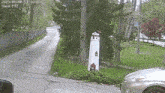 a car is parked in front of a lighthouse in a driveway