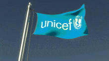 a blue unicef flag flies in the wind