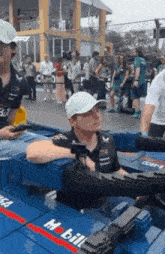 a man in a white hat is sitting in a container with a camera on it .