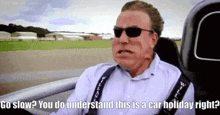 a man wearing sunglasses is sitting in a car and says `` go slow ? you do understand this is a car holiday right ?