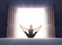 a woman is doing a yoga pose in front of an open door