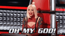 a woman is sitting in front of a red wall and says oh my god .