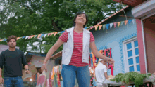a woman in a red and white striped shirt is dancing in front of a man