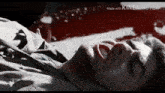 a man is laying on the ground with his mouth open and blood coming out of his nose .