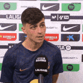 a man stands in front of a wall that has laliga tv written on it