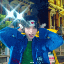 a young man wearing a headband with a heart on it is wearing a blue jacket