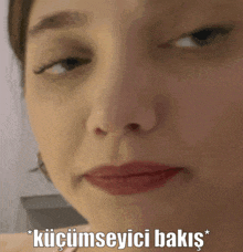 a close up of a woman 's face with the words " küçümseyici bakus " written below her