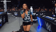 a woman wearing a jersey with the number 55 on it blows a kiss