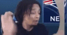a woman is sitting in front of a sign that says ne