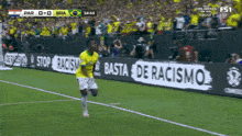 a soccer player is running on the field with a sign that says basta de racismo