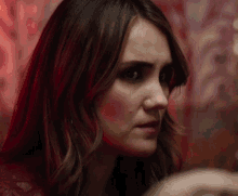 a close up of a woman 's face with a serious look on her face