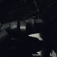 a black and white photo of a person holding a gun with the letters ms below it