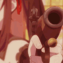 a woman is holding a gun in her hand and pointing it at the camera .