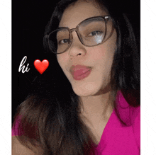 a woman wearing glasses and a pink shirt says hi next to a heart