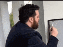 a man with a beard is drawing a circle on a white board