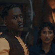 a man with braids and a mustache is looking at something