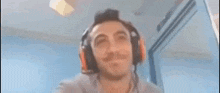 a man wearing headphones and a microphone is looking up .