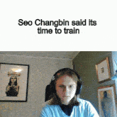 a person wearing headphones with the words seo changbin said its time to train below them