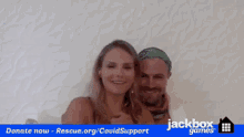 a man and a woman are standing next to each other in front of a sign that says jackbox games on it