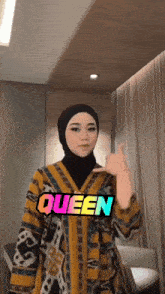 a woman wearing a hijab and a yellow jacket with queen written on it