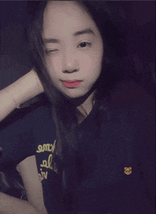a girl wearing a shirt that says smv on it winks at the camera