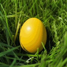 a yellow egg is sitting in the grass with a green background