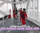 a group of people are standing on a metal staircase with a sign that says ' s41m ' on it