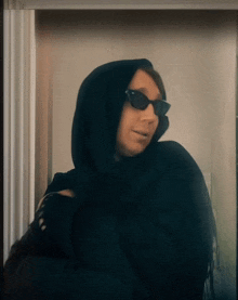 a person wearing sunglasses and a black scarf