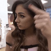 a woman in a pink and black dress is holding her hair in her hand
