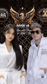 a man and a woman are standing in front of a sign that says " divisi 25 "