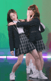 two girls in school uniforms are posing for a photo