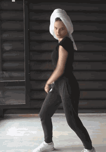a woman with a towel around her head is dancing