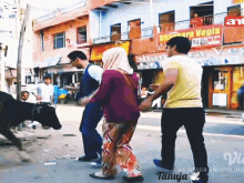 a group of people are walking down a street in front of a sign that says shankar vegis