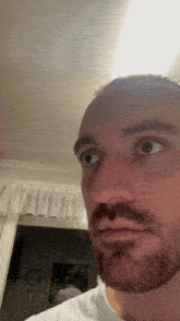 a man with a beard looks at the camera