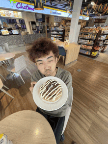 a man is holding a plate of food in front of a store that says chatime