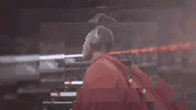a man wearing a red nike glove looks at something