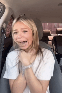 a woman in a car with her mouth wide open