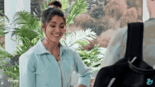 a woman is smiling in front of a disney advertisement