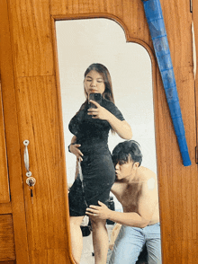 a woman taking a picture of herself in a mirror