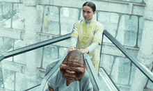 a woman in a yellow uniform is standing next to an alien