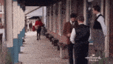 a group of men are standing in front of a hallmark drama building