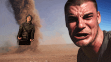 a man is crying in front of a man standing in the sand