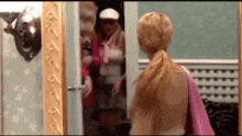 a woman is standing in front of a mirror looking at herself in a mirror .